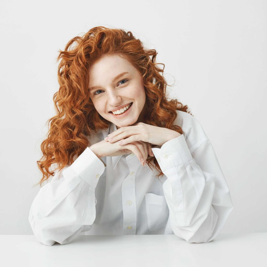 beautiful_redhead_woman_with_curly_hair_smiling_looking_camera_sitting beautiful_redhead_woman_with_curly_hair_smiling_looking_camera_sitting